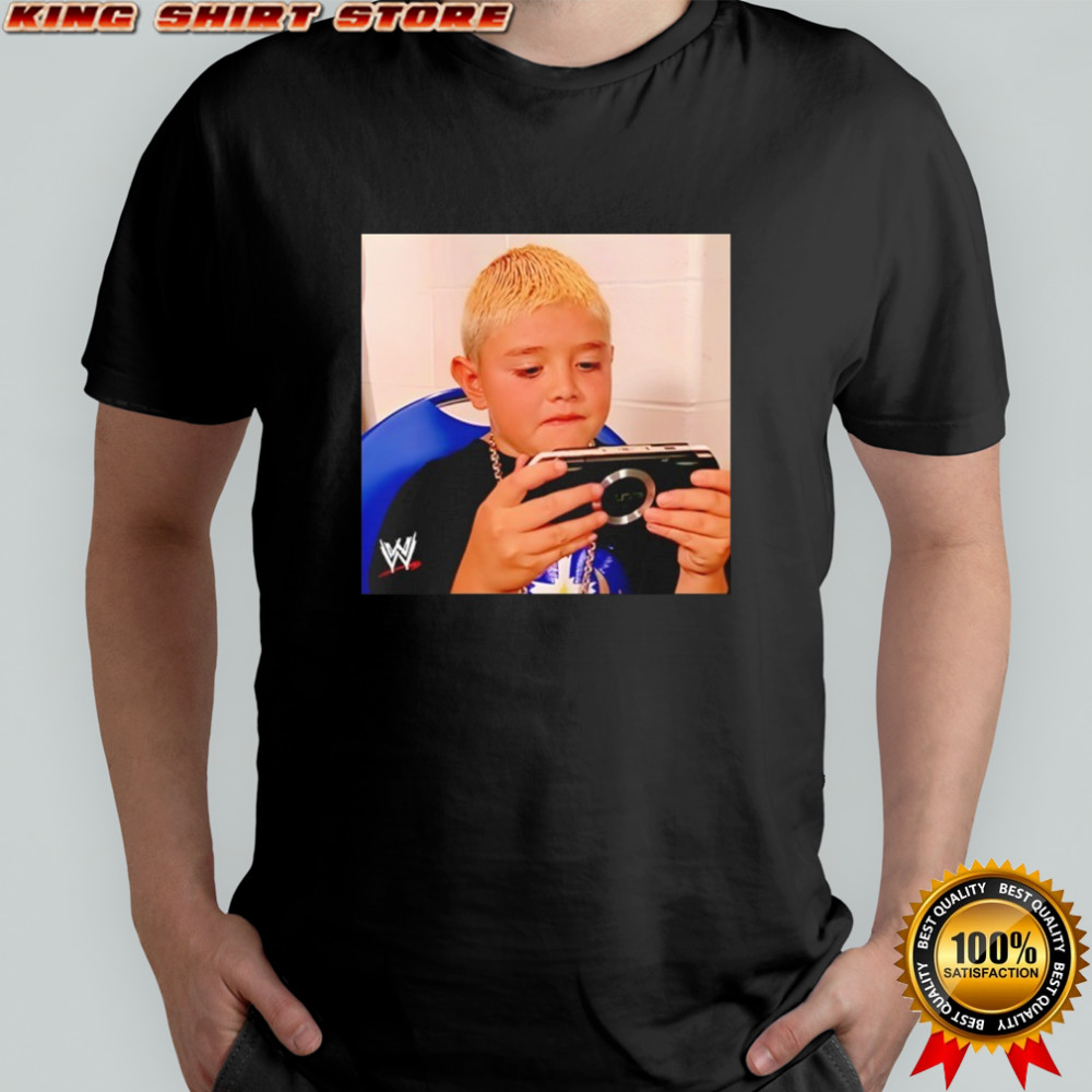 Dominik Mysterio wearing his younger self playing the PSP shirt